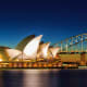 Sydney Opera House illuminated at dusk with Sydney Harbour Bridge in background, Australia